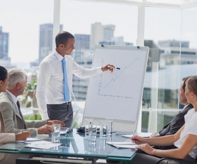 Manager pointing at the peak of a chart during a meeting in the meeting room