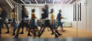 Businesspeople walking at modern office. Group of business employees at coworking center. Motion blur. Concept work process. Wide image