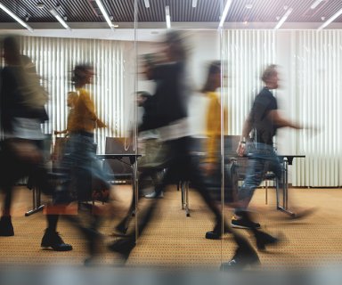 Businesspeople walking at modern office. Group of business employees at coworking center. Motion blur. Concept work process. Wide image