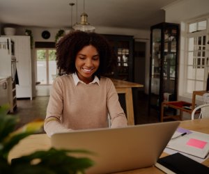 Successful young businesswoman entrepreneur working on laptop from home office space