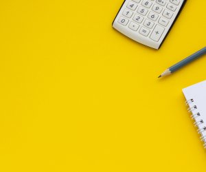 Calculator, notepad and pencil on a yellow background, space for text